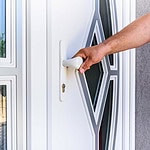 a hand holding a white upvc door handle